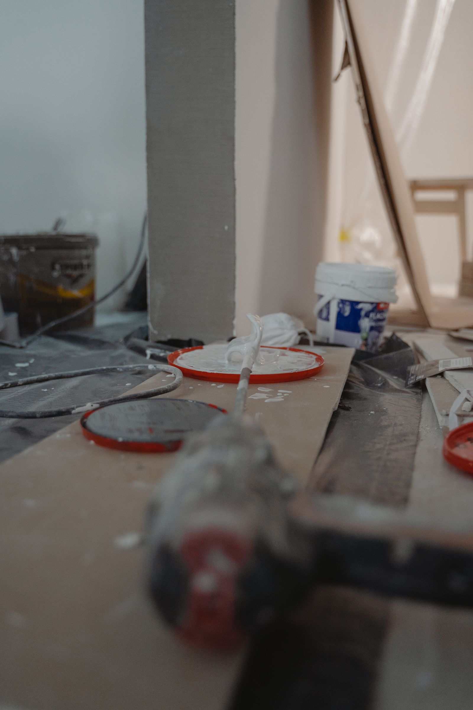 Close-up of construction tools and materials laid out on the floor of a job site.