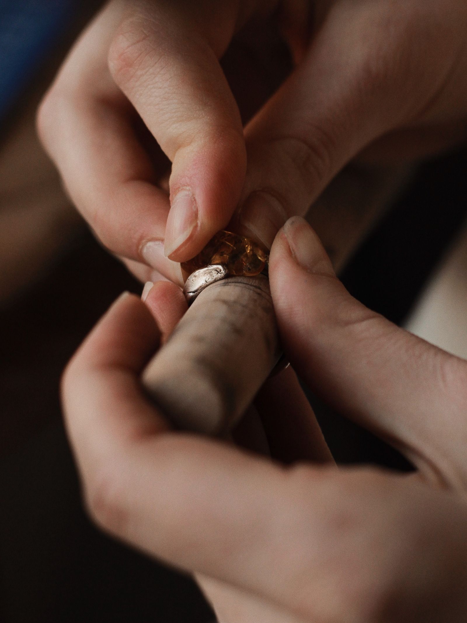 Close-up of a potter's hands shaping wet clay on a spinning wheel, the maker's face out of frame.