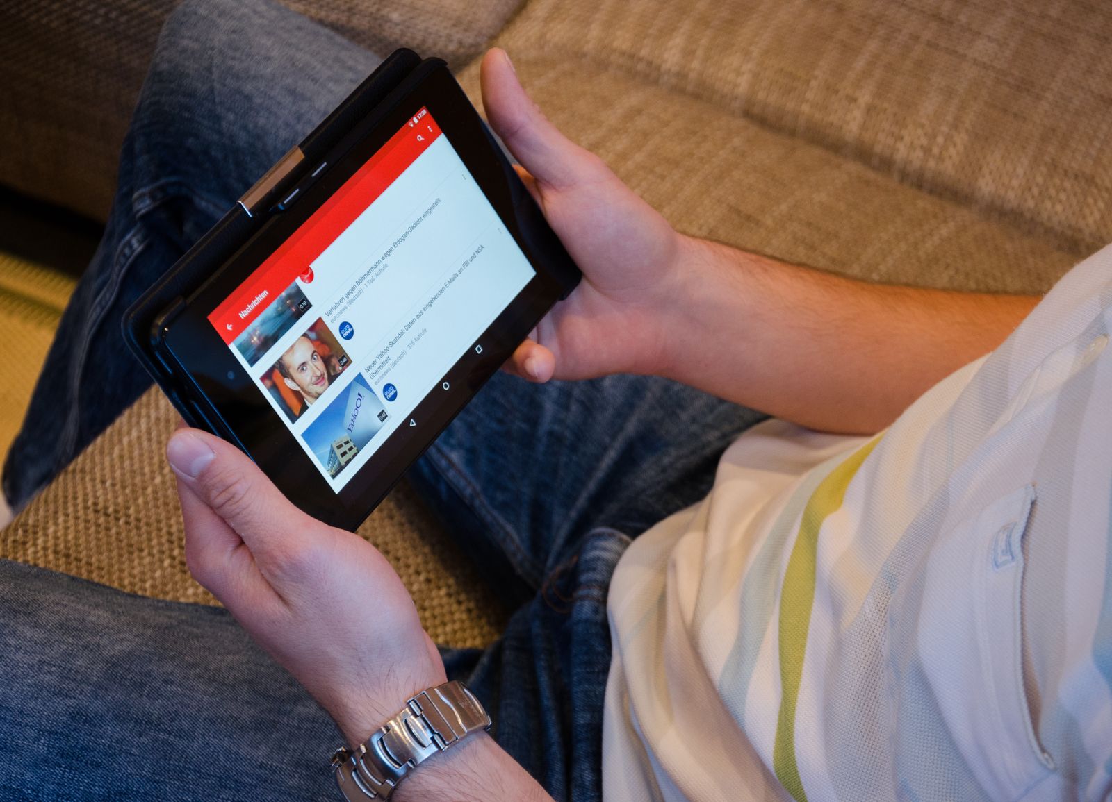 A person holding a tablet, watching a video on a streaming app